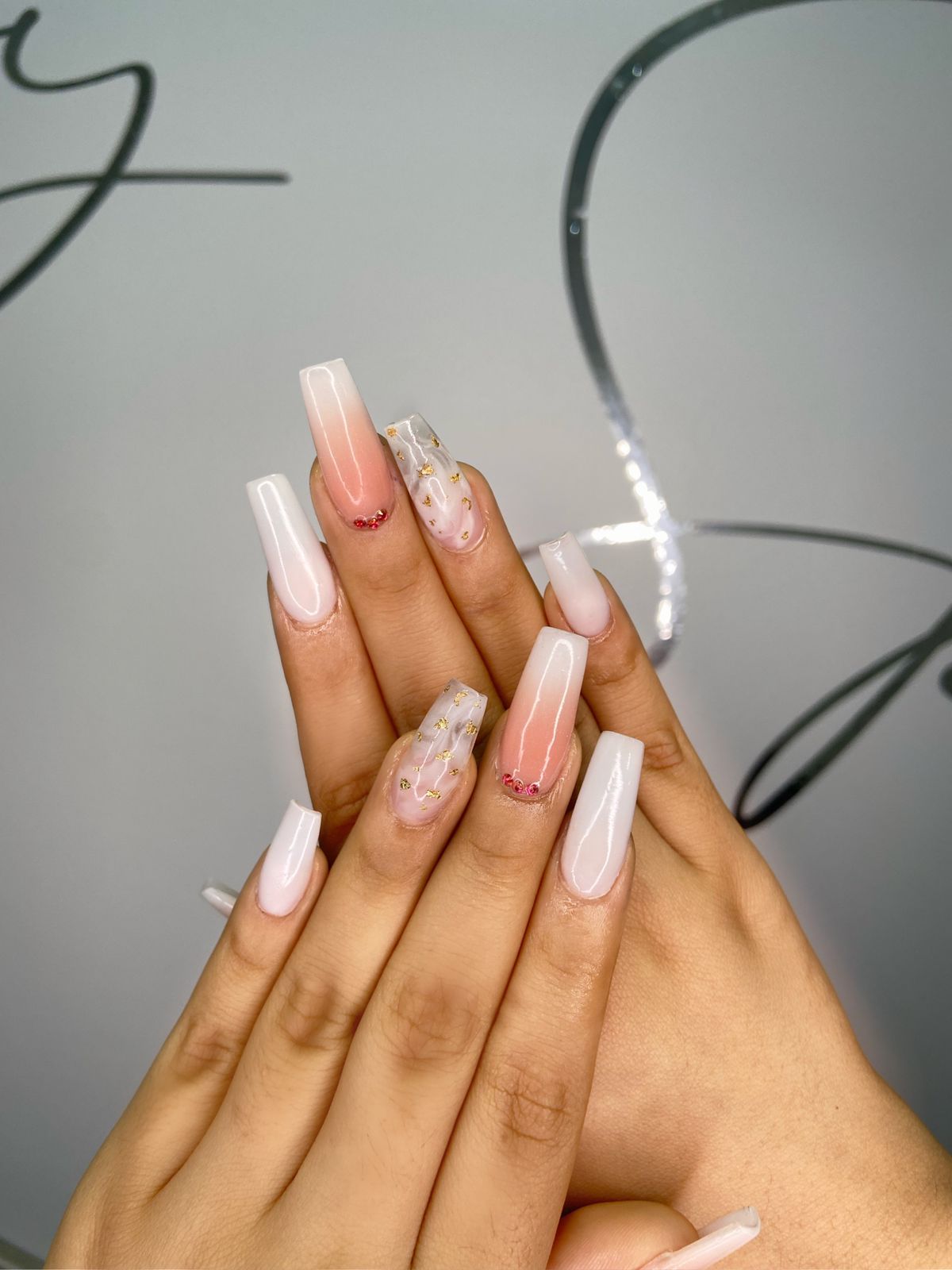 Uñas largas esmaltadas frente al logo de Day Spa