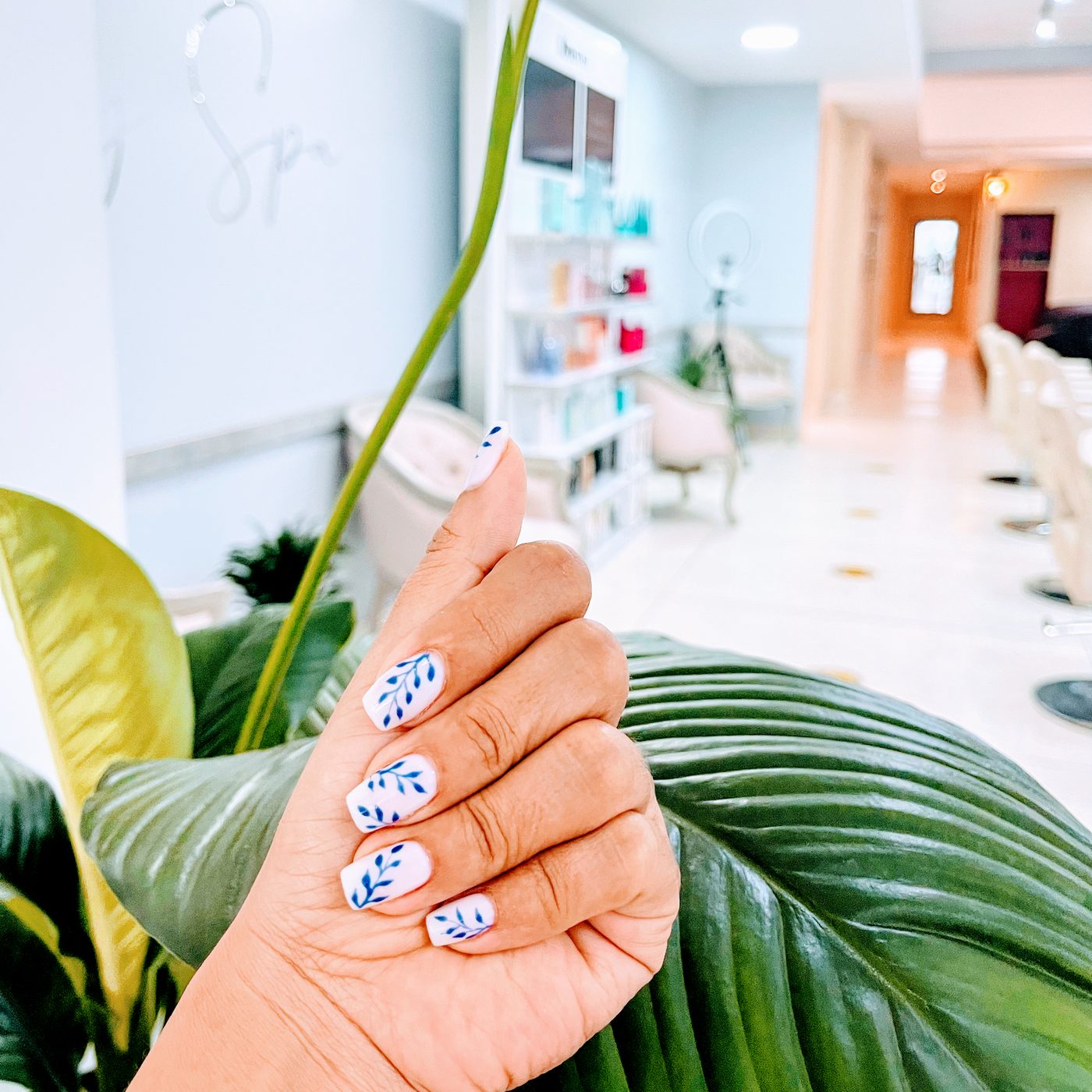 Manicure con diseño de hojas azules en el salón de Day Spa
