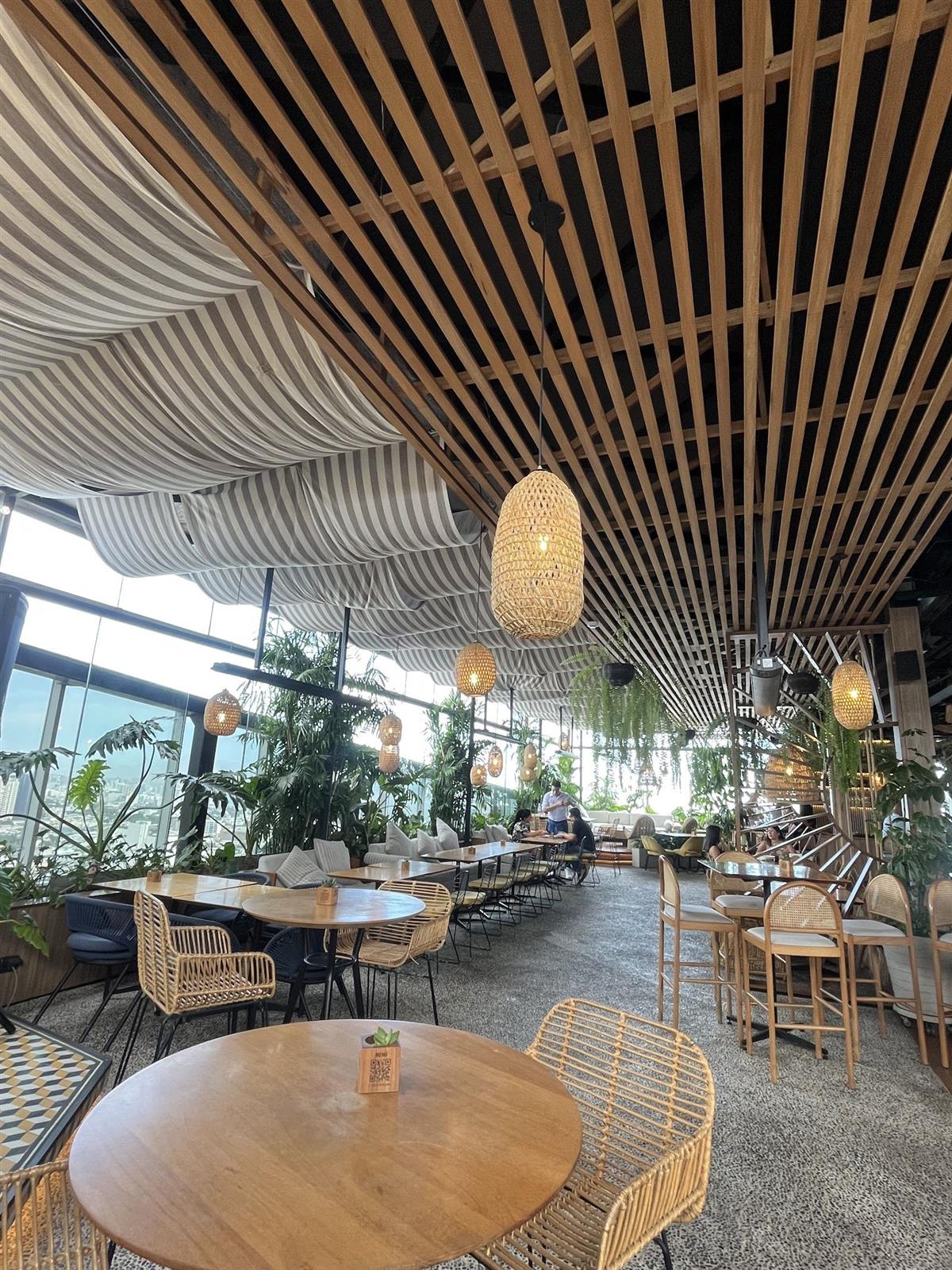 Terraza de Vista Corona con techo de listones de madera, lámparas de mimbre y vista panorámica de Lima